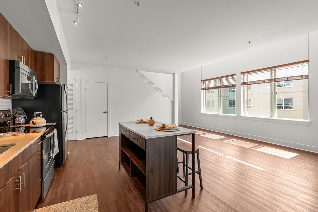 A kitchen with wooden cabinets and a black fridge.