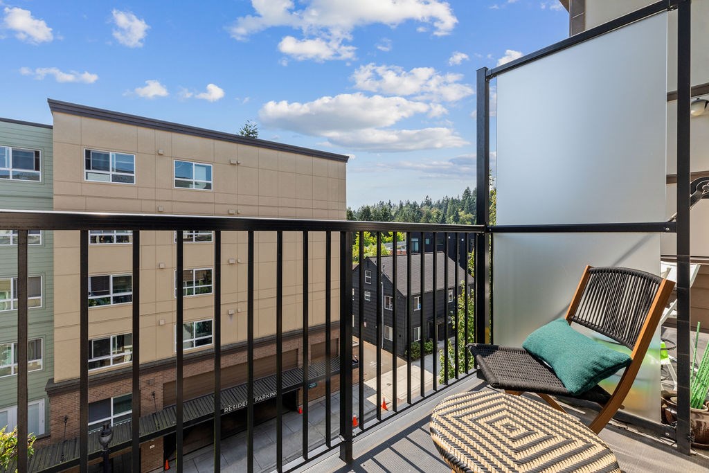 A balcony with a chair and a table with a white screen on the right.