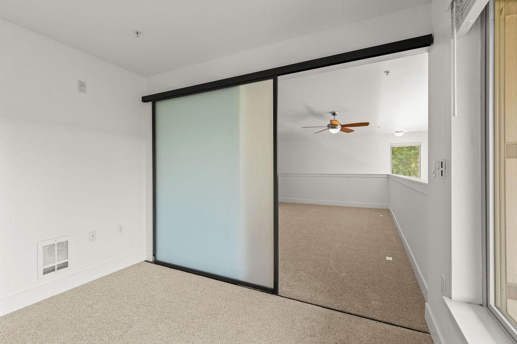 A room with a sliding door and a ceiling fan.