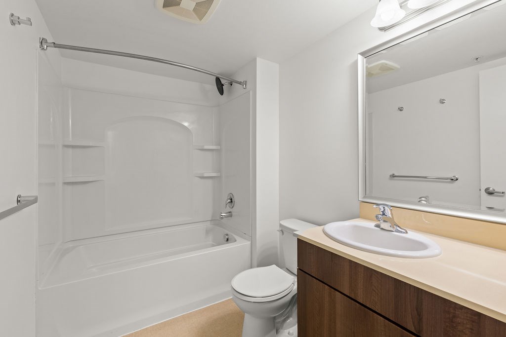 A white bathroom with a toilet, sink, and bathtub.