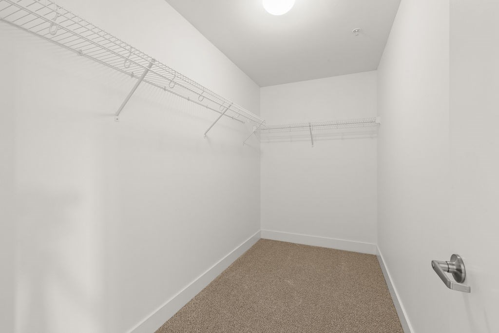 A white room with a carpeted floor and a light on the ceiling.