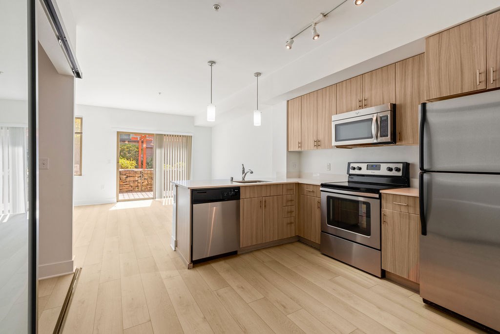 A modern kitchen with wooden cabinets and stainless steel appliances.