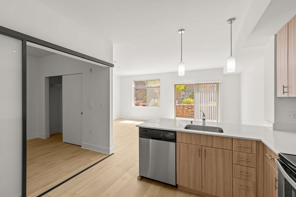 A modern kitchen with wooden cabinets and a stainless steel dishwasher.