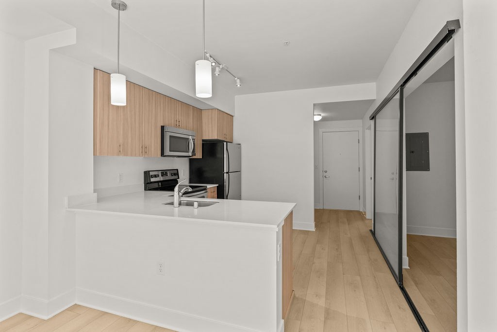 A kitchen with a white counter and wooden cabinets.