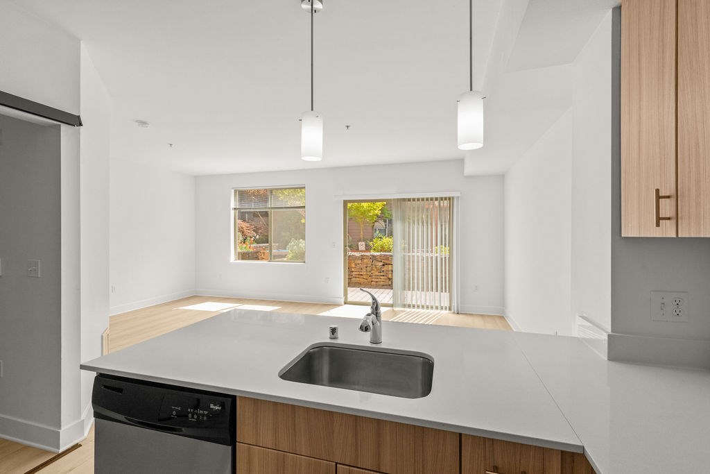 A modern kitchen with a black dishwasher and a window.