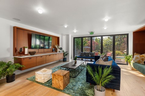 A living room with a blue couch and a wooden floor.
