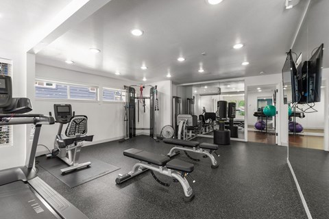 A spacious gym with a variety of equipment including treadmills, weights, and exercise machines.