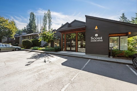 A Scout Leasing Office building with a parking lot in front.