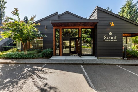 A Scout Leasing Office building with a parking lot in front.