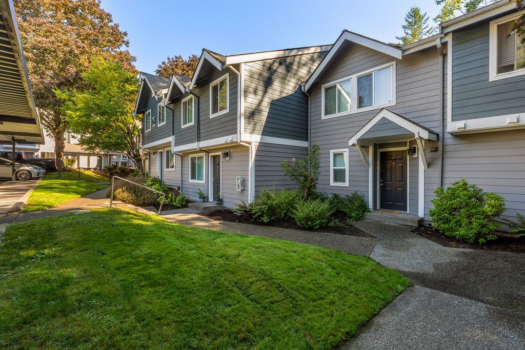A row of houses with green lawns in front.