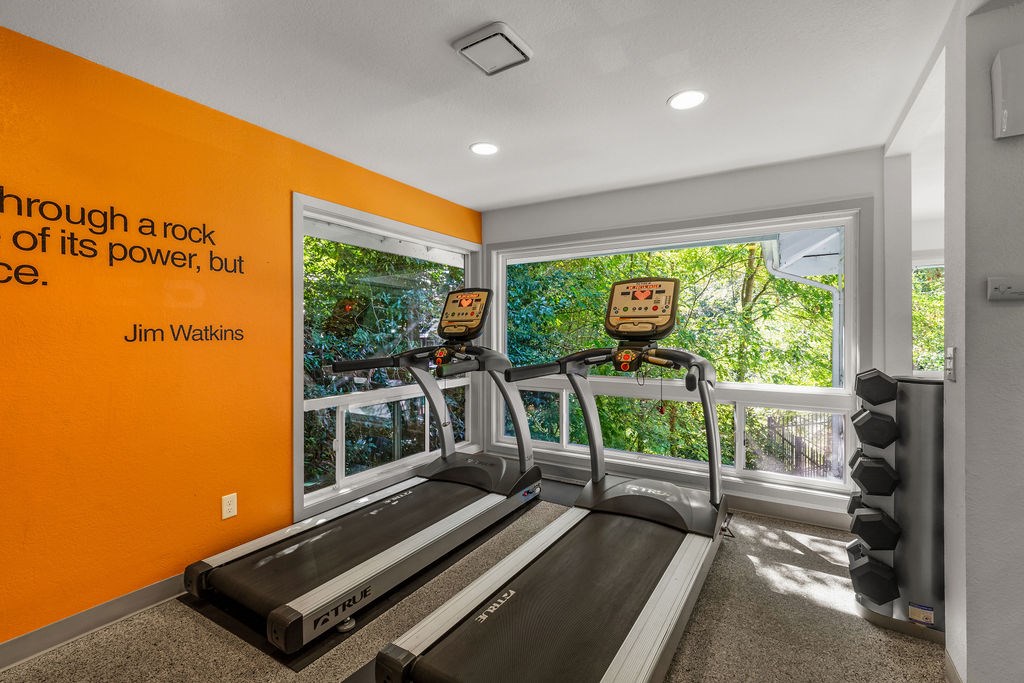 A treadmill in a room with a quote by Jim Watkins on the wall.