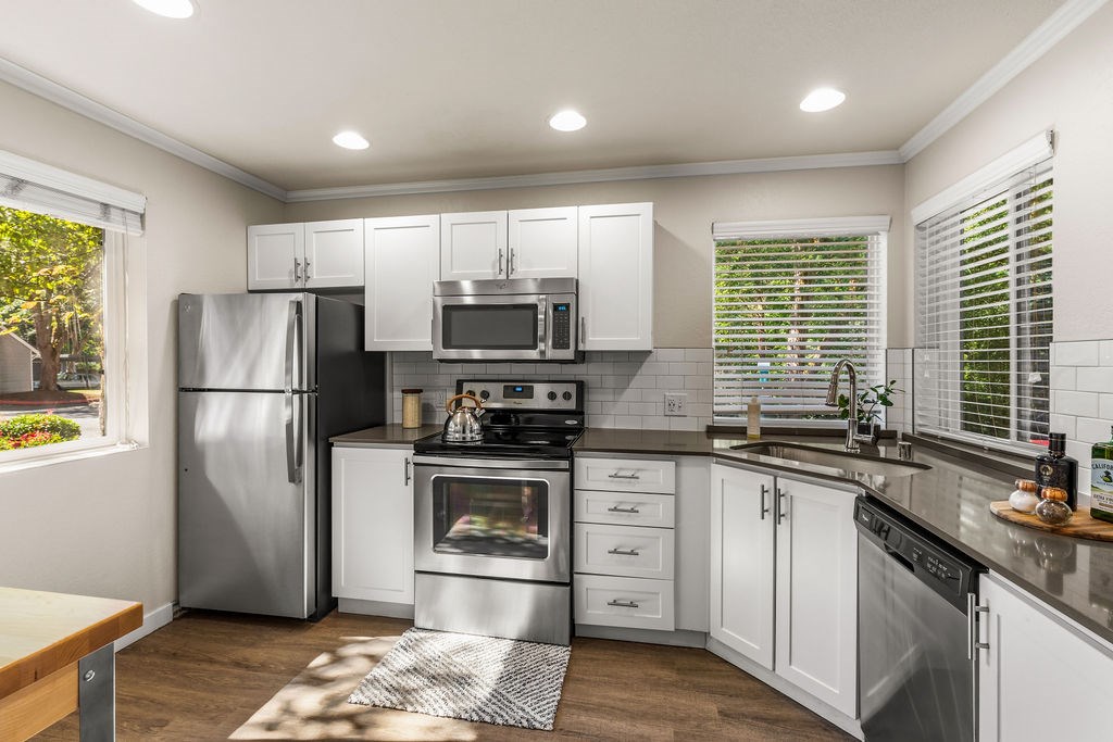 A modern kitchen with stainless steel appliances and white cabinets.