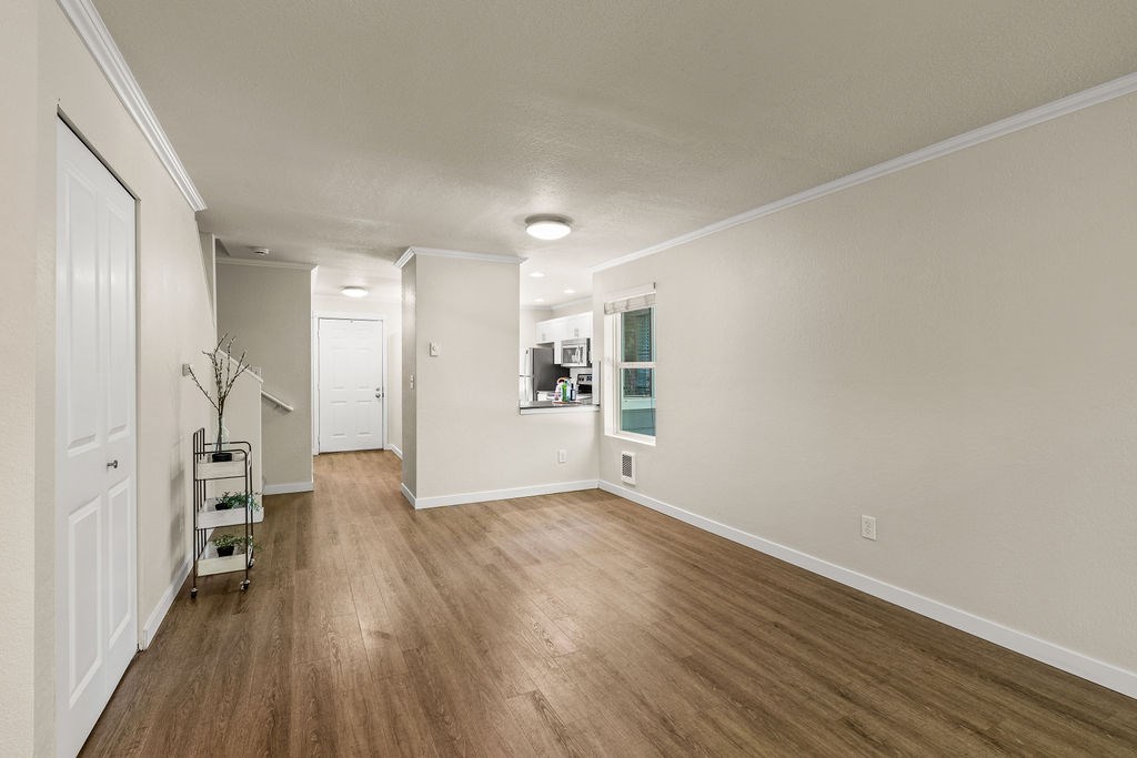 A long hallway with wood floors and white walls.