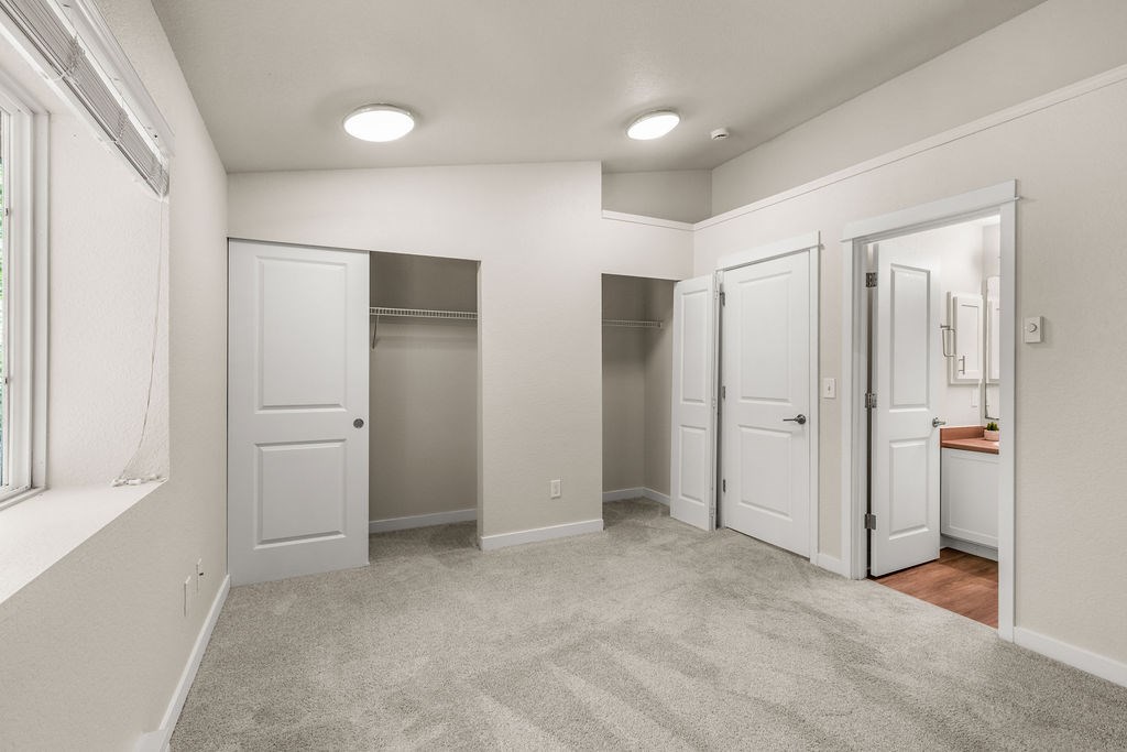 A spacious room with a carpeted floor and white walls.