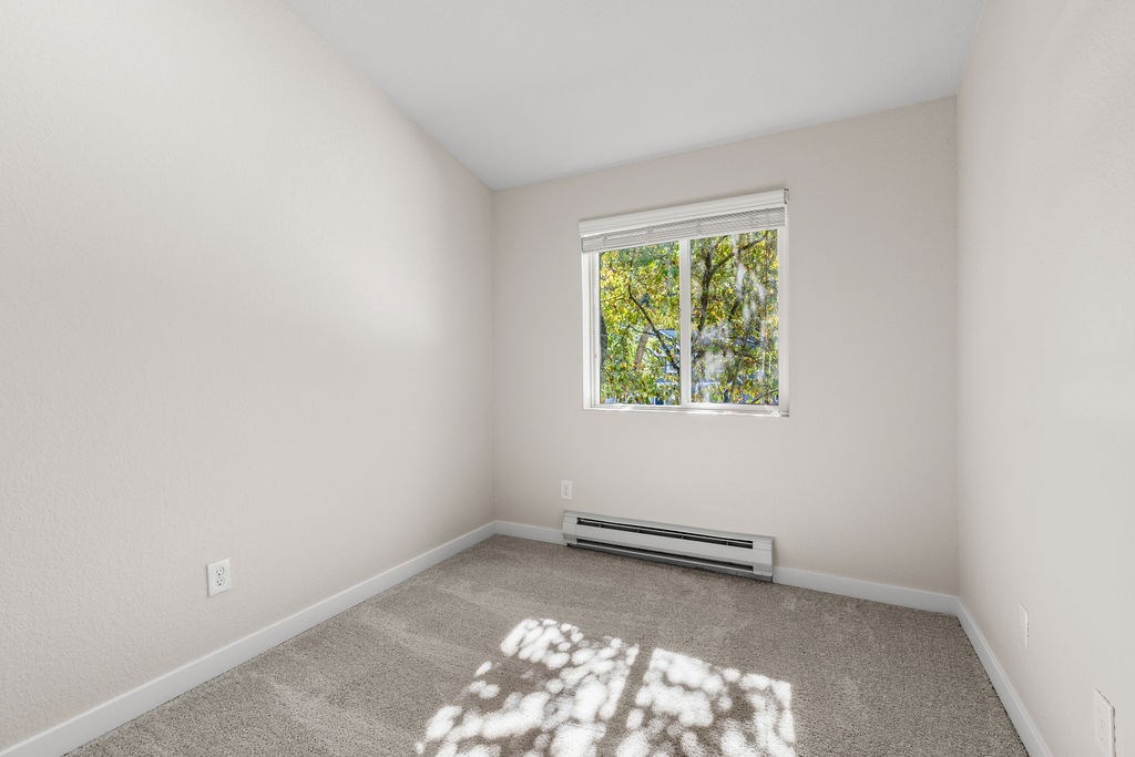 A room with a window and a carpet on the floor.