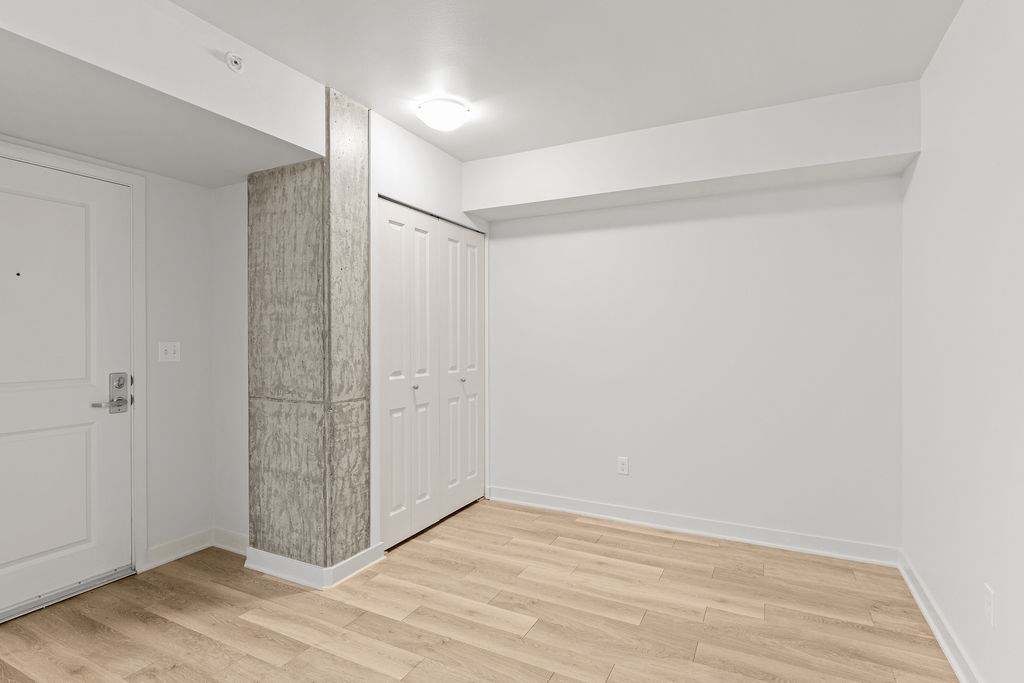 A room with a white door and a wooden floor.