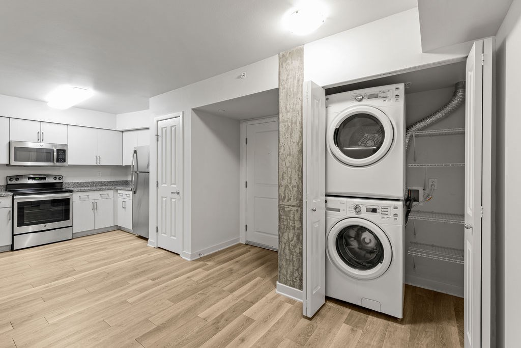 A modern kitchen with a washing machine in the wall.