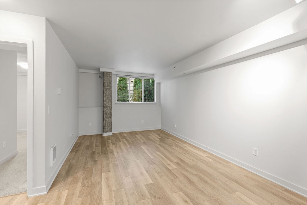 A room with wooden flooring and white walls.
