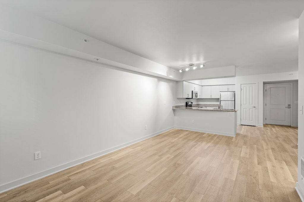 A room with wooden flooring and white walls.