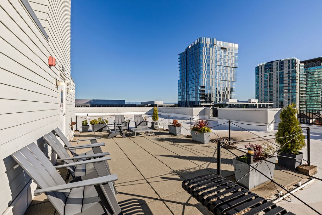 A patio with chairs and a table with a view of a cityscape.