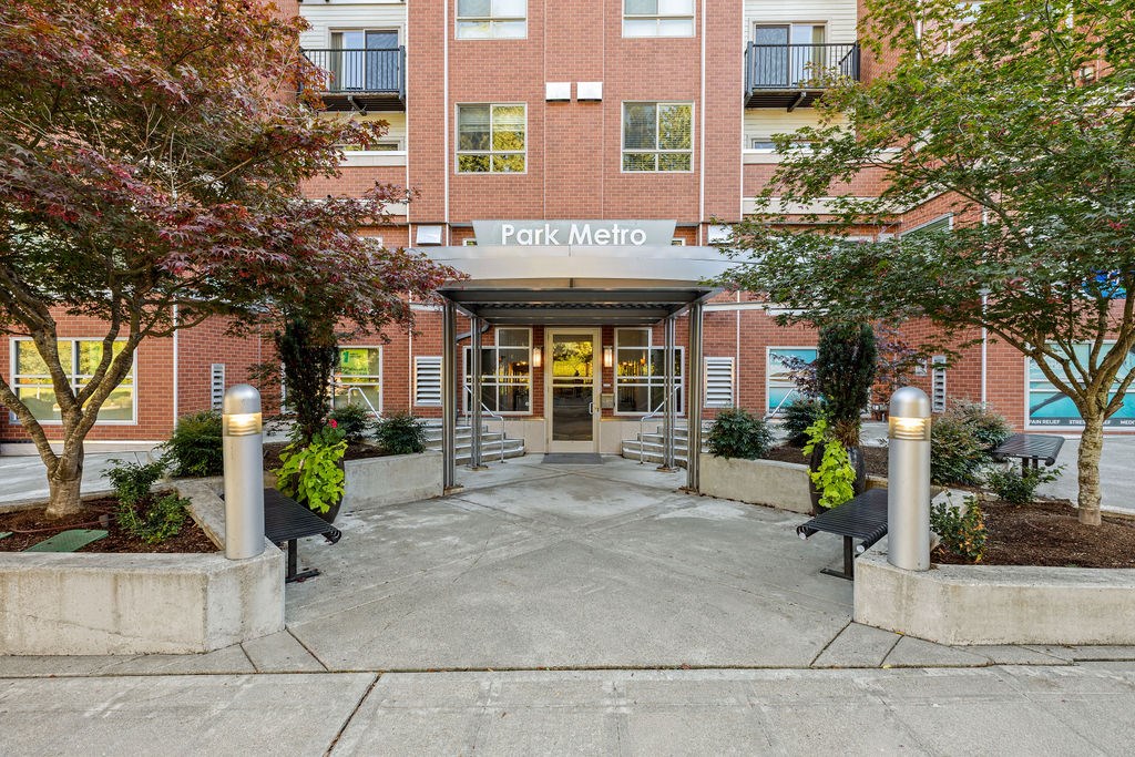 The entrance to a building named Park Metro with a glass door and a canopy.
