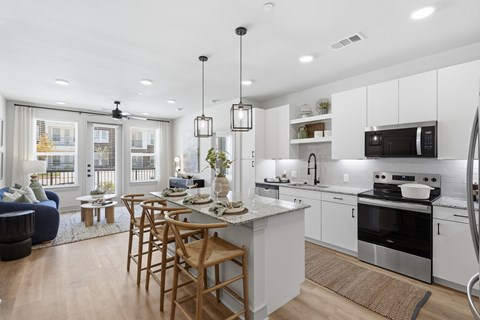 A modern kitchen with white cabinets and a large island.
