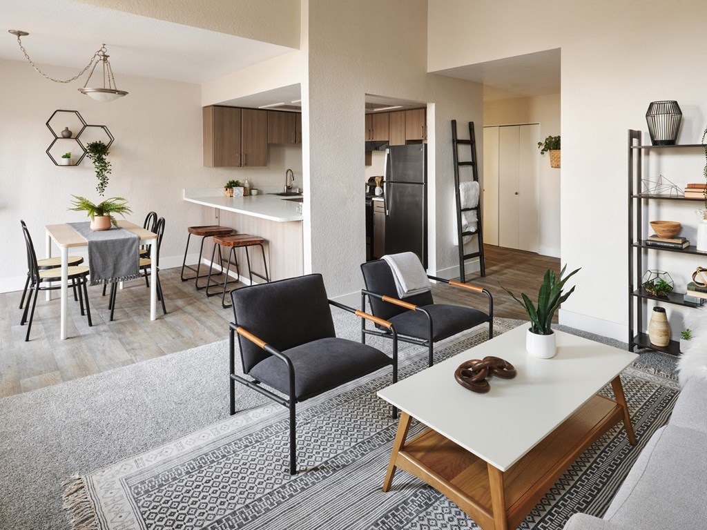 a living room with a dining area and a kitchen in the background