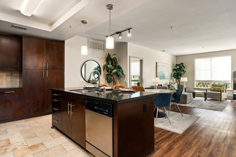 A modern kitchen with dark wood cabinets and a large island.