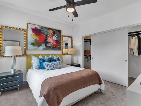 A bedroom with a large bed and a painting on the wall.