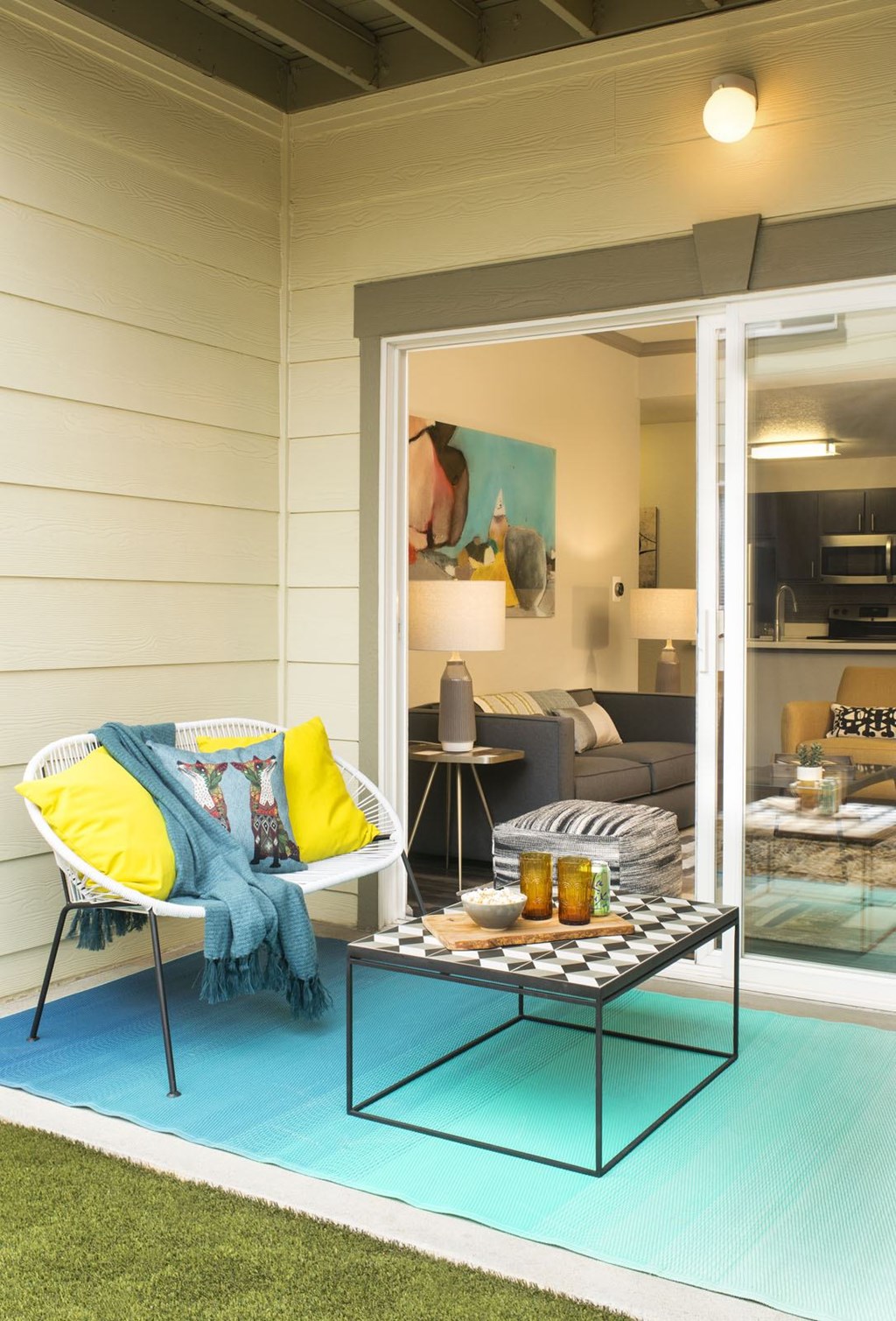 A white chair with a blue blanket is on a blue rug.