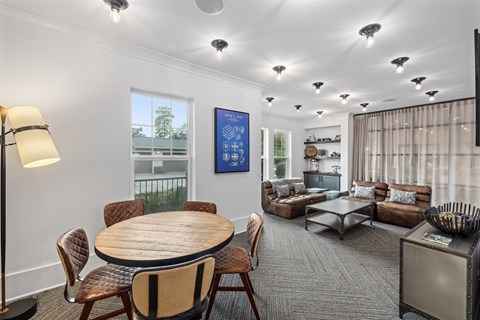 A living room with a wooden table surrounded by chairs.