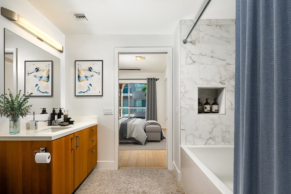 a bathroom with a tub and a sink and a mirror  at The LC, Los Angeles