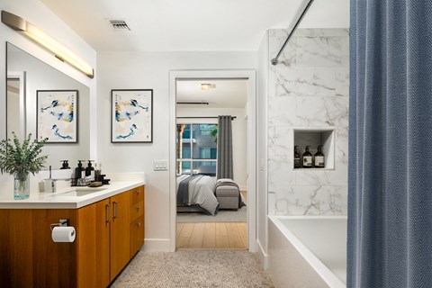 a bathroom with a tub and a sink and a mirror  at The LC, Los Angeles