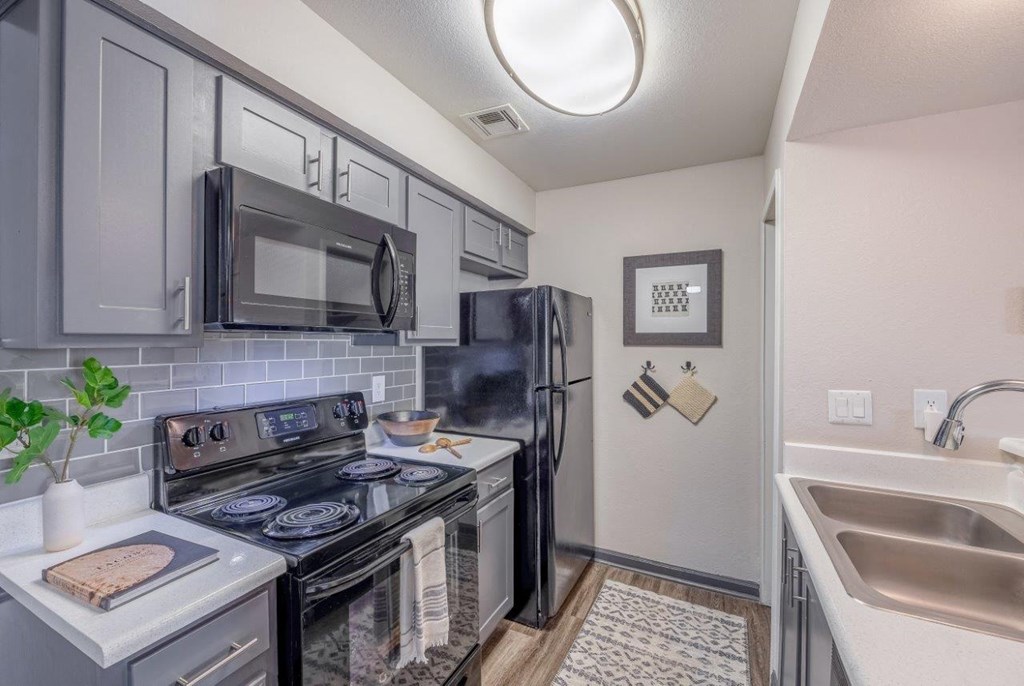 a kitchen with stainless steel appliances and a black refrigerator