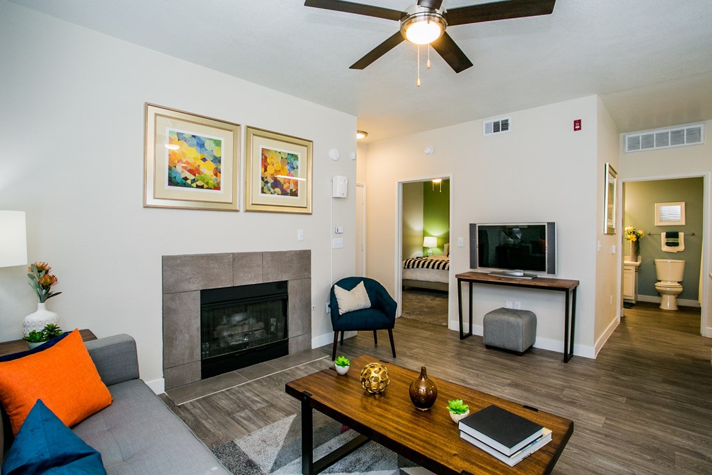 A living room with a fireplace, a chair, a coffee table, and a television.
