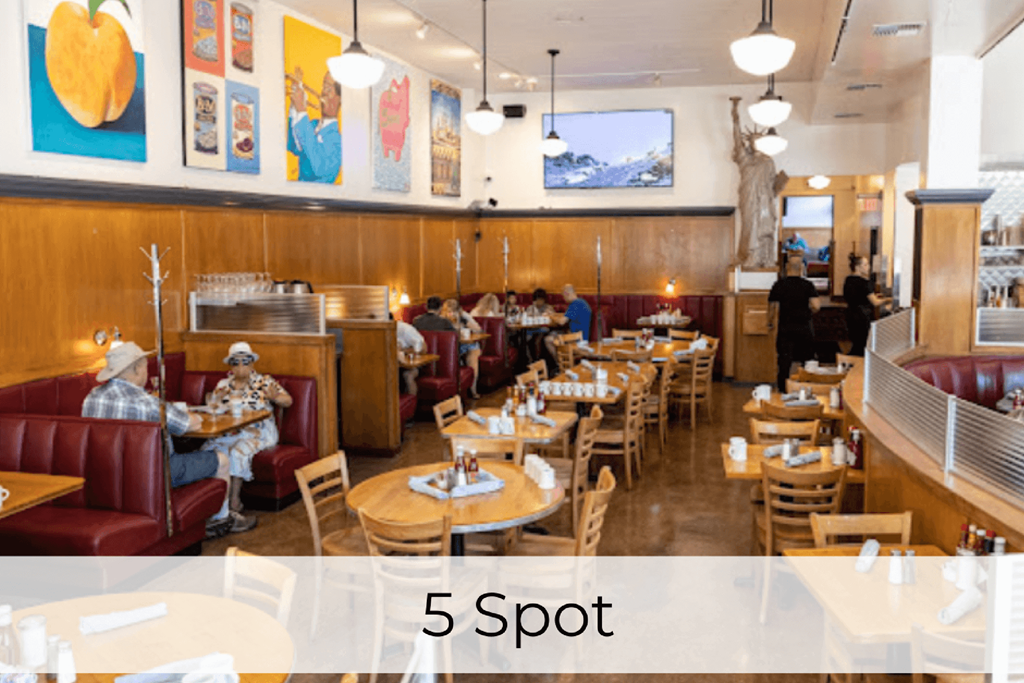 A restaurant with wooden booths and tables with people sitting and eating.