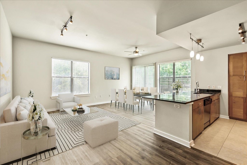 a living and dining room area with white walls and hardwood flooring