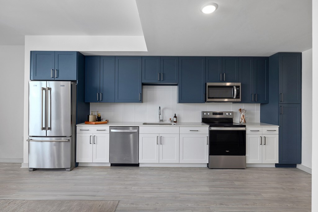 A kitchen with blue cabinets and stainless steel appliances.