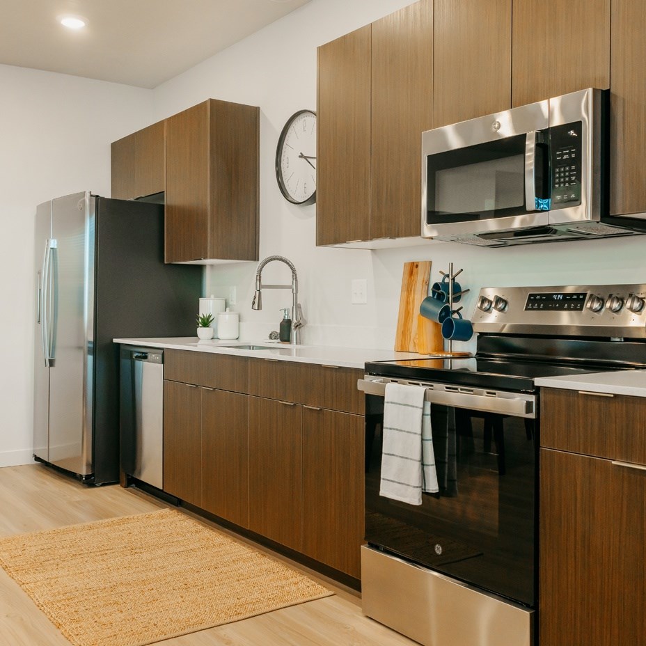 A modern kitchen with a stainless steel oven and wooden cabinets.
