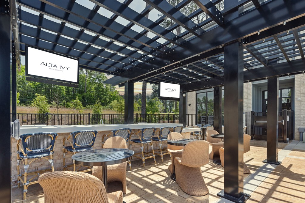 A patio with tables and chairs under a roof with