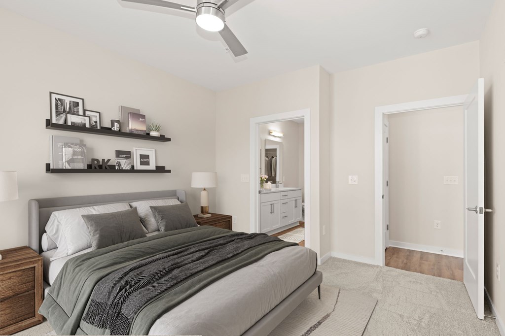 A bedroom with a bed, nightstand, and a ceiling fan.