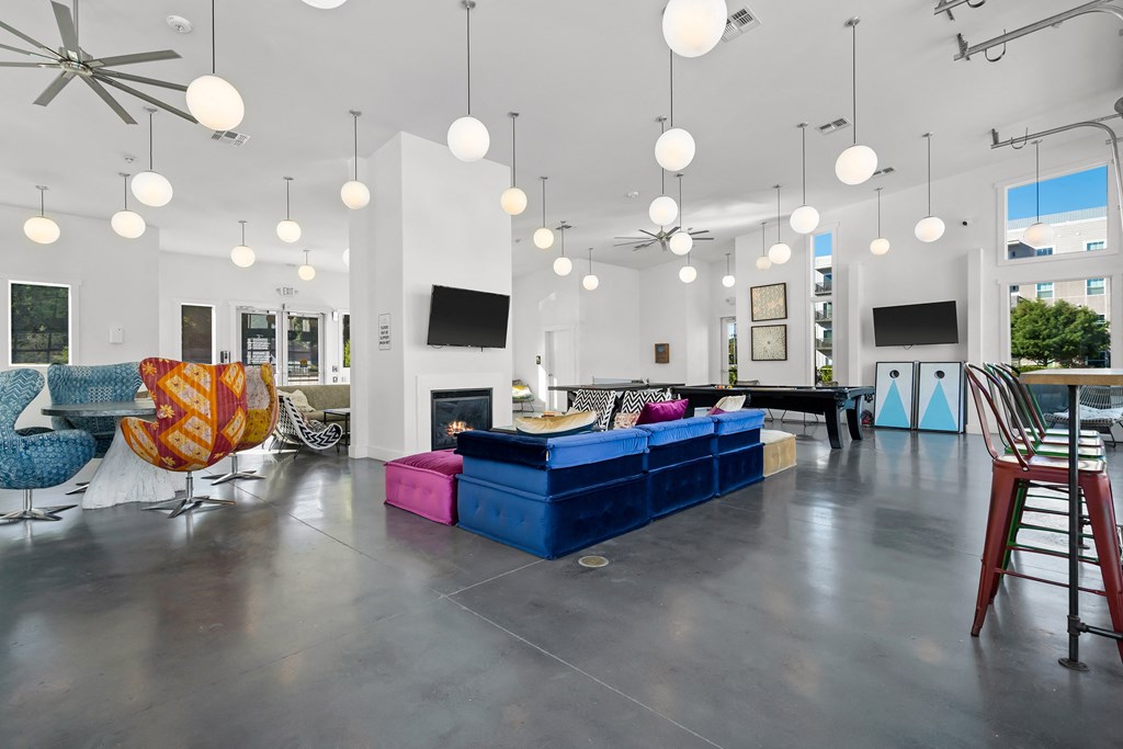 Open lounge area with seating, TV and multiple pendant lights