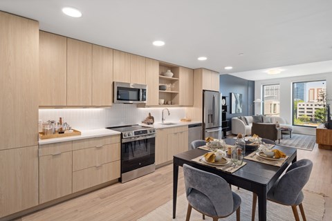 A modern kitchen with a dining table set for two.