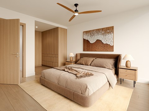 A bedroom with a large bed and a ceiling fan.