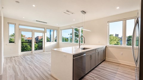 A modern kitchen with a large island and stainless steel appliances.