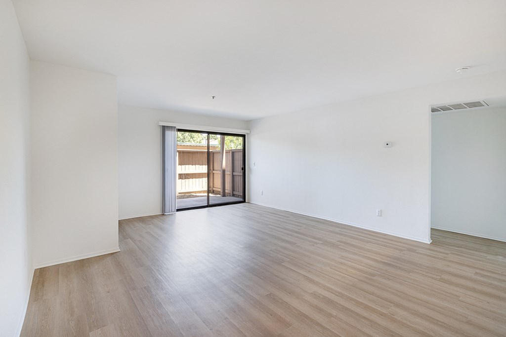 a bedroom with hardwood floors and white walls