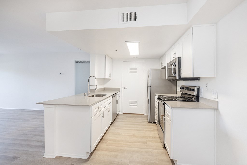 a kitchen with white cabinets and stainless steel appliances