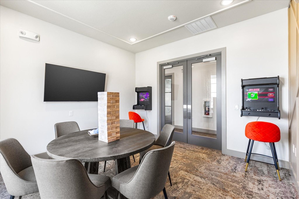 a conference room with a round table and chairs and a flat screen tv on the wall