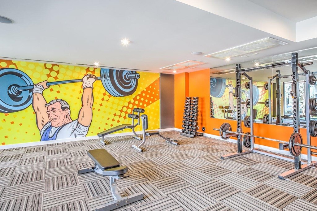 a workout room with a large mural of a man holding a barbell
