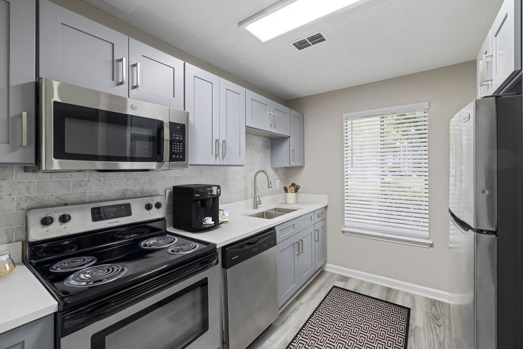 a kitchen with stainless steel appliances and white cabinets